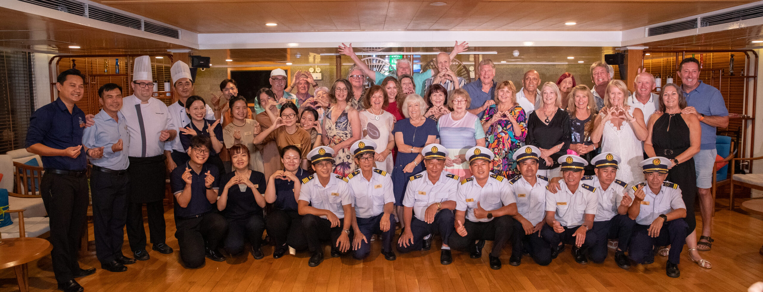 Guests and Victoria Mekong Cruises crew sharing a joyful moment together on board